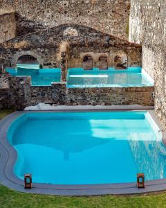 an outdoor pool with blue water and a stone wall at Hacienda Santa Maria Regla in Huasca de Ocampo