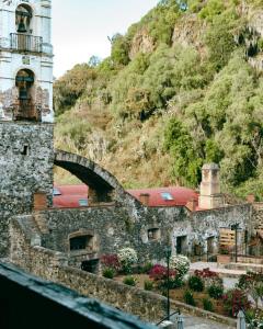 a stone building with a tower and a bridge at Hacienda Santa Maria Regla in Huasca de Ocampo +9 photos