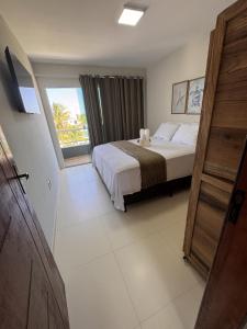 a bedroom with a bed and a large window at Refúgio Cachoeira Guaibim in Guaibim +74 photos
