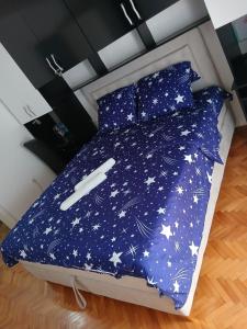 a bed with a blue comforter with stars on it at Apartman TADEJ in Zvornik