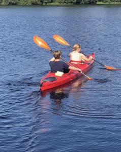 two people in a red kayak on the water at Dalälven Strand in Södersätra
