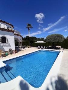 a swimming pool in front of a house at villa PLAYA RUSTICAL in Miami Platja