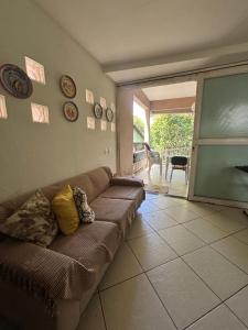 a living room with a couch and a sliding glass door at Refúgio Aconchegante com Varanda para Natureza in Resende