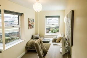 a living room with a couch and two windows at Fishergate Apartments in Preston