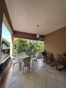 a balcony with a table and chairs and a view at Refúgio Aconchegante com Varanda para Natureza in Resende