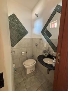 a bathroom with a toilet and a sink at Refúgio Aconchegante com Varanda para Natureza in Resende
