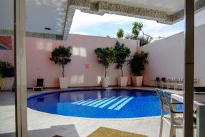 a large swimming pool in a building with chairs around it at Hotel Laffayette Ejecutivo in Guadalajara