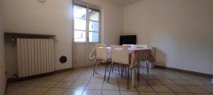 a room with a table with chairs and a window at Alloggio Maia 2 in Biella