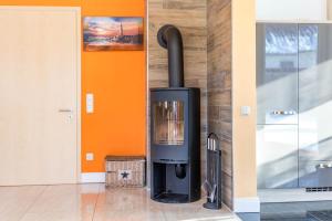 a fireplace in a room with an orange wall at Villa Strandoase in Wohlenberg
