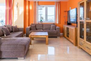a living room with two couches and a tv at Villa Strandoase in Wohlenberg