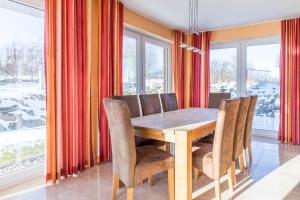 a dining room with a wooden table and chairs at Villa Strandoase in Wohlenberg