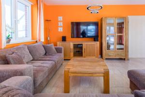 a living room with a couch and a tv at Villa Strandoase in Wohlenberg