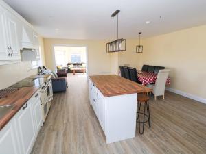a kitchen and living room with a counter and a table at Tí Tom Nárta in Trawbaun
