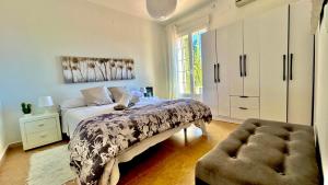 a bedroom with a bed and a chair and a cabinet at Marife Home in Guillena +25 photos