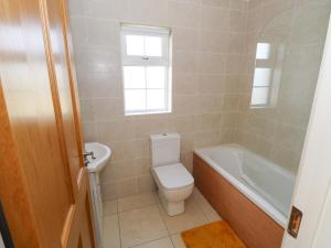 a bathroom with a toilet and a tub and a sink at Tí Tom Nárta in Trawbaun +21 photos