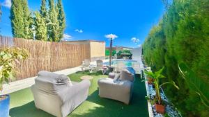 a garden with two chairs and a pool in a backyard at Marife Home in Guillena