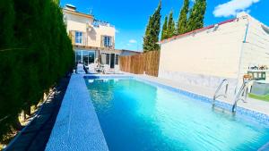 a swimming pool in front of a house at Marife Home in Guillena