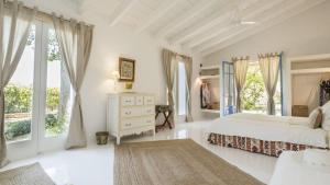 a white bedroom with a bed and large windows at Finca Son Miranda in Sencelles +106 photos