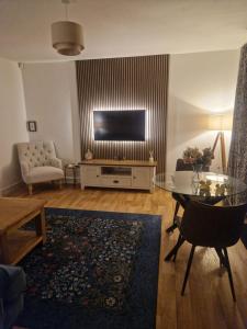 a living room with a flat screen tv on a wall at Honeybee Hideaway in Brompton