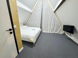 a small room with a bed and a tv at Căsuțele Ritei in Săpânța +91 photos