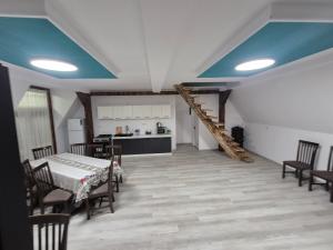 a living room with a table and chairs and a kitchen at Căsuțele Ritei in Săpânța