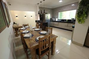 a kitchen and dining room with a wooden table and chairs at Pousada House Garden in Goiânia