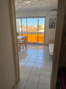 a view of a room with a table and a balcony at Studio Horizon in Palavas-les-Flots