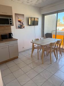 a kitchen with a table and chairs in a room at Studio Horizon in Palavas-les-Flots