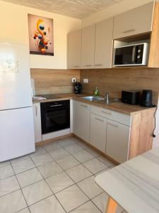 a kitchen with a white refrigerator and a sink at Studio Horizon in Palavas-les-Flots