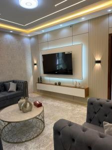 a living room with a tv and a couch and a table at High-floor Luxury Apartment! in Ajman 