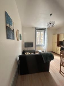 a living room with a couch and a table at L azur Jurassien séjour chaleureux dans le Jura in Saint-Claude
