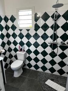 a bathroom with a black and white checkered wall at Ti ÉMERAUDE in Pointe-Noire