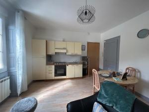 a living room with a table and a kitchen at L azur Jurassien séjour chaleureux dans le Jura in Saint-Claude