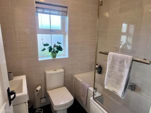 a bathroom with a toilet and a window at 56 Woodlands in Clonakilty +6 photos