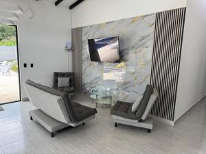 a lobby with two chairs and a tv on a wall at Villa Alma in Medellín