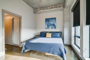 a bedroom with a bed with a blue comforter at Sable 901 - Penthouse in Minneapolis +27 photos