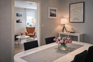 a dining room with a table with a vase of flowers at Apartment 19 in Selfoss