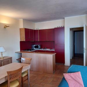 a kitchen with red cabinets and a table with chairs at Residence Il Vigneto in Oggebbio