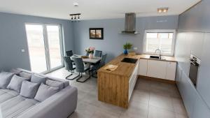 a kitchen and living room with a couch and a table at Prestige House Jacuzzi & Sauna in Gdańsk