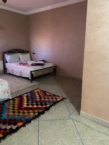 a bedroom with a bed and a rug on the floor at Double Room in Telouet
