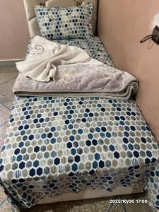 a bed with a blue and white comforter on it at Double Room in Telouet