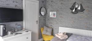 a living room with a yellow chair and a mirror at Kirkhill Cottage B&B in Crossmichael