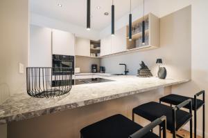 a kitchen with white cabinets and black stools at Strandgeflüster deluxe in Zingst