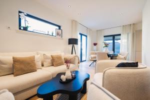 a living room with a couch and chairs and a table at Strandgeflüster deluxe in Zingst