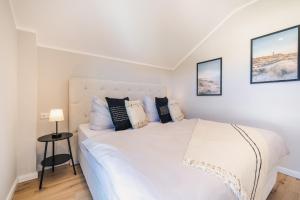 a bedroom with a large white bed with pillows at Strandgeflüster deluxe in Zingst