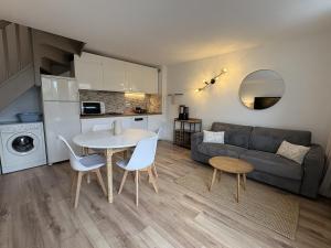 a living room with a couch and a table and chairs at Escales du Sud, Frontignan Plage in Frontignan