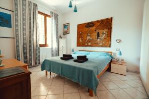 a bedroom with a bed with a blue blanket at Seaside Beach House with Private Parking in Punta Marina +19 photos