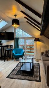 a living room with a blue couch and a table at Villa K2 in Karpacz