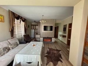 a living room with a couch and a table at Ивелия Къща за гости in Dospat