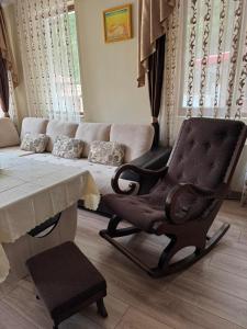 a living room with a couch and a chair at Ивелия Къща за гости in Dospat +77 photos